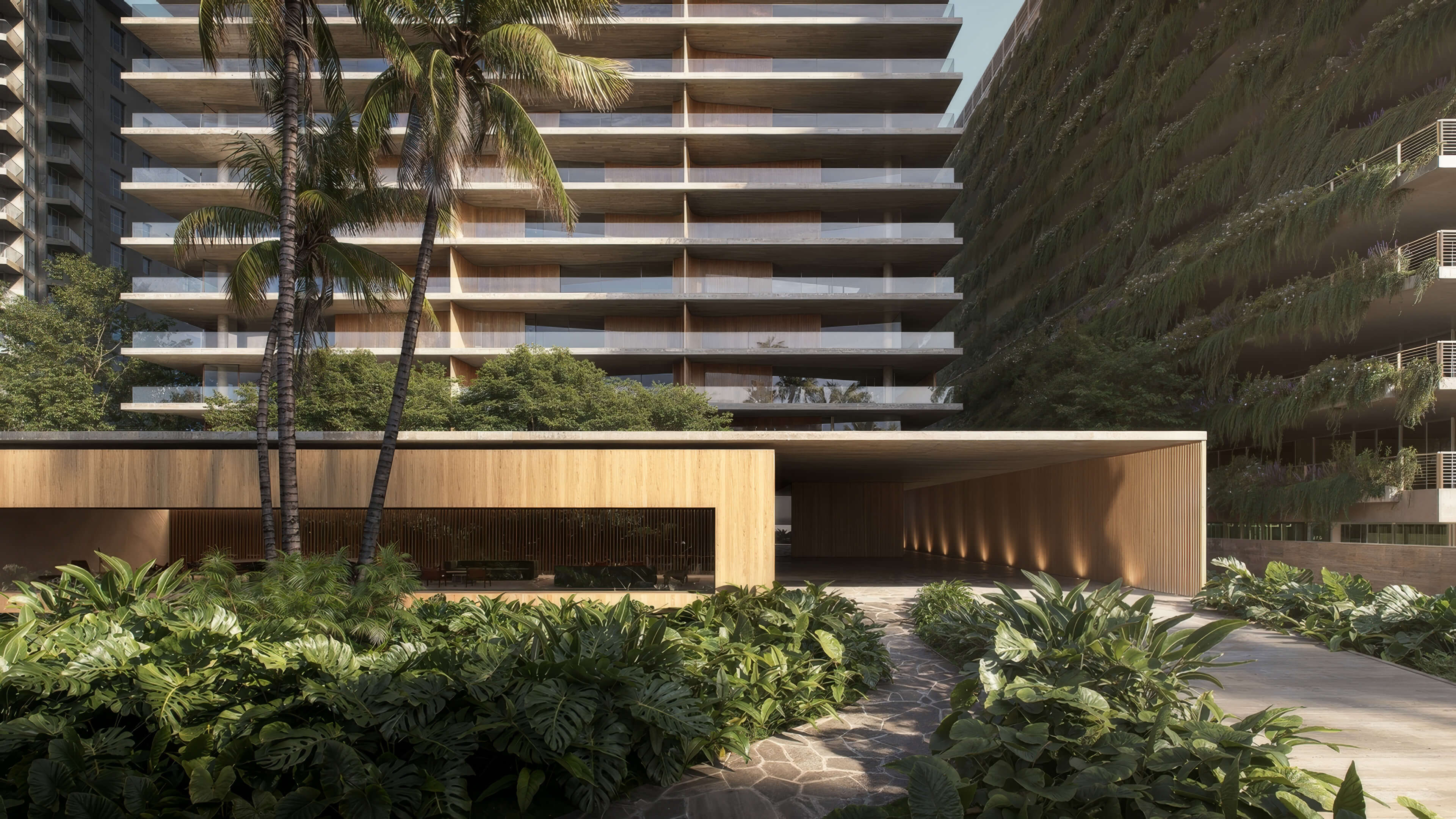 Landscaped driveway entrance at 1250 West Avenue Residences, framed by palms and a planted wall.