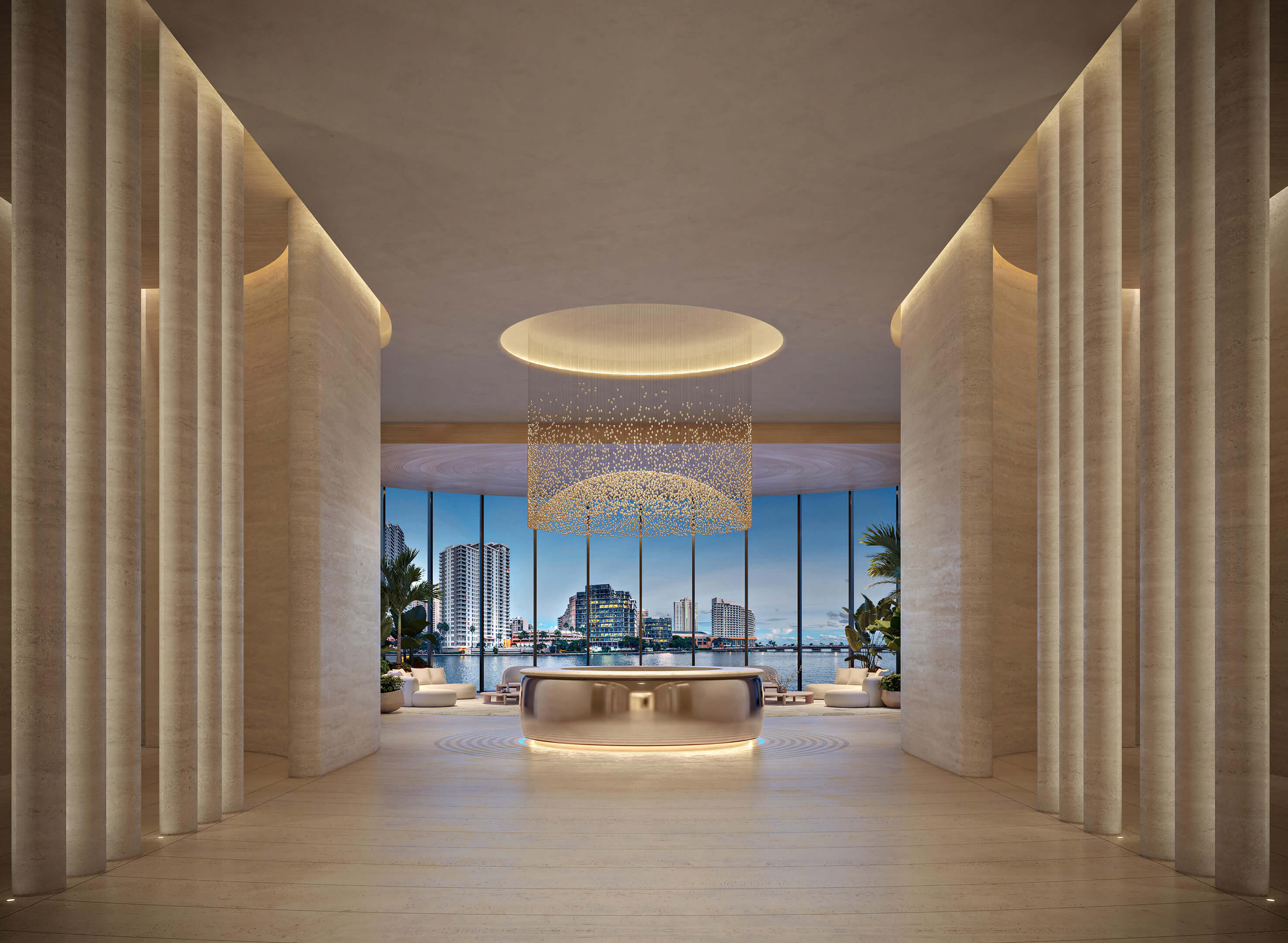 Elegant lobby at 619 Brickell Residences with dramatic chandelier, stone columns, and waterfront views