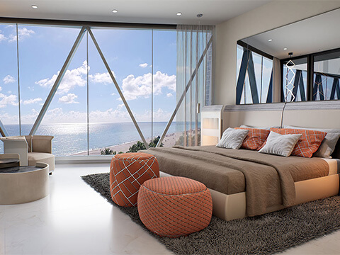Bentley Residences bedroom with ocean views and orange accent seating