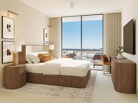 Cassia Residences Coral Gables bedroom with private balcony view, warm wood furnishings, and bright contemporary design
