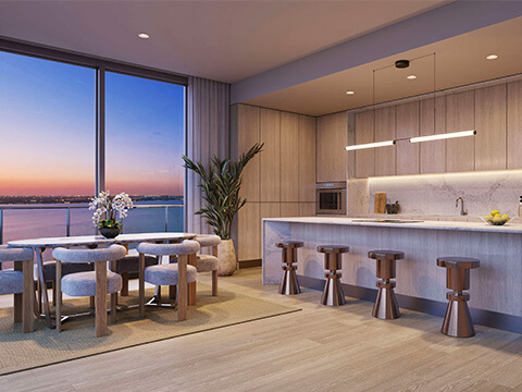 Modern kitchen and dining area at Continuum Club & Residences with sunset water views