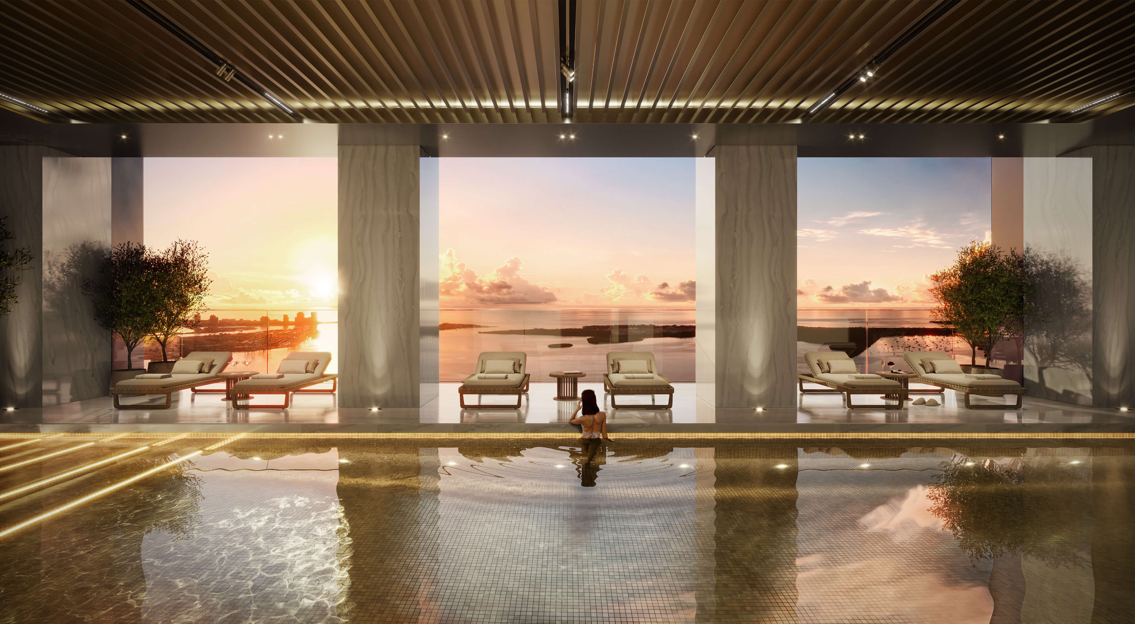 Indoor pool at 888 Brickell Ave with ocean view and serene sunset through floor-to-ceiling windows