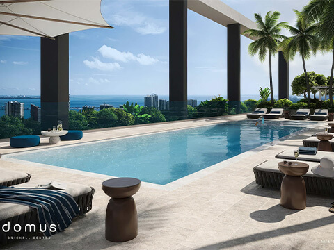 Rooftop infinity pool at Domus Brickell Center with luxury loungers, palm trees, and panoramic Biscayne Bay views