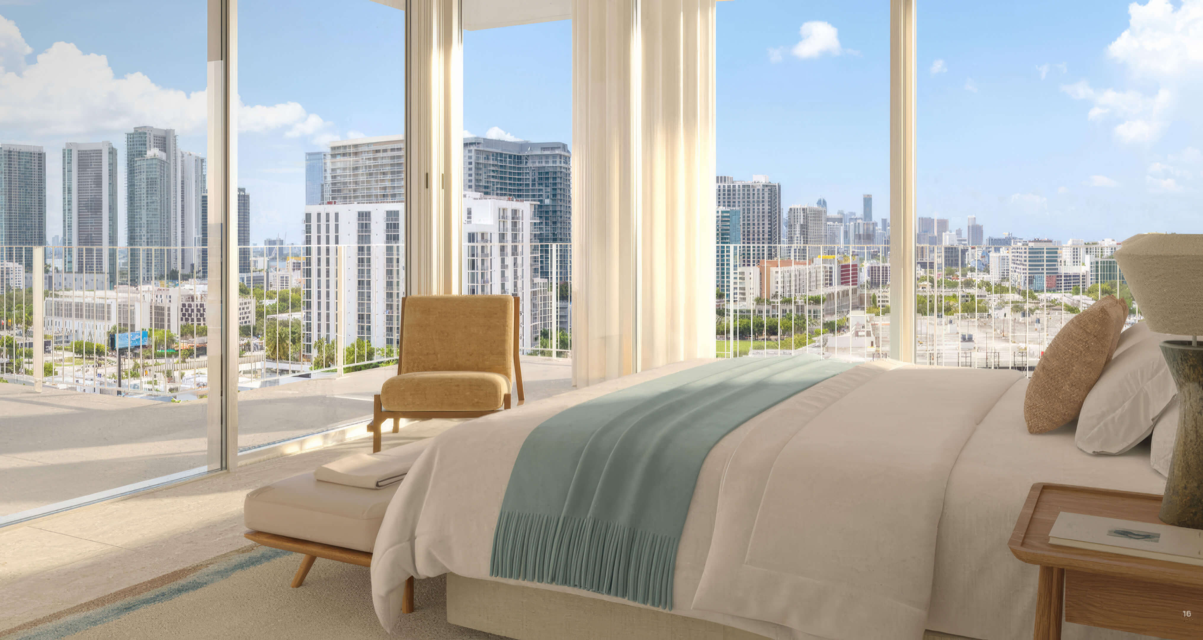 Bedroom with a blue bed throw and expansive windows overlooking the skyline at Fouquet’s Hotel & Residences