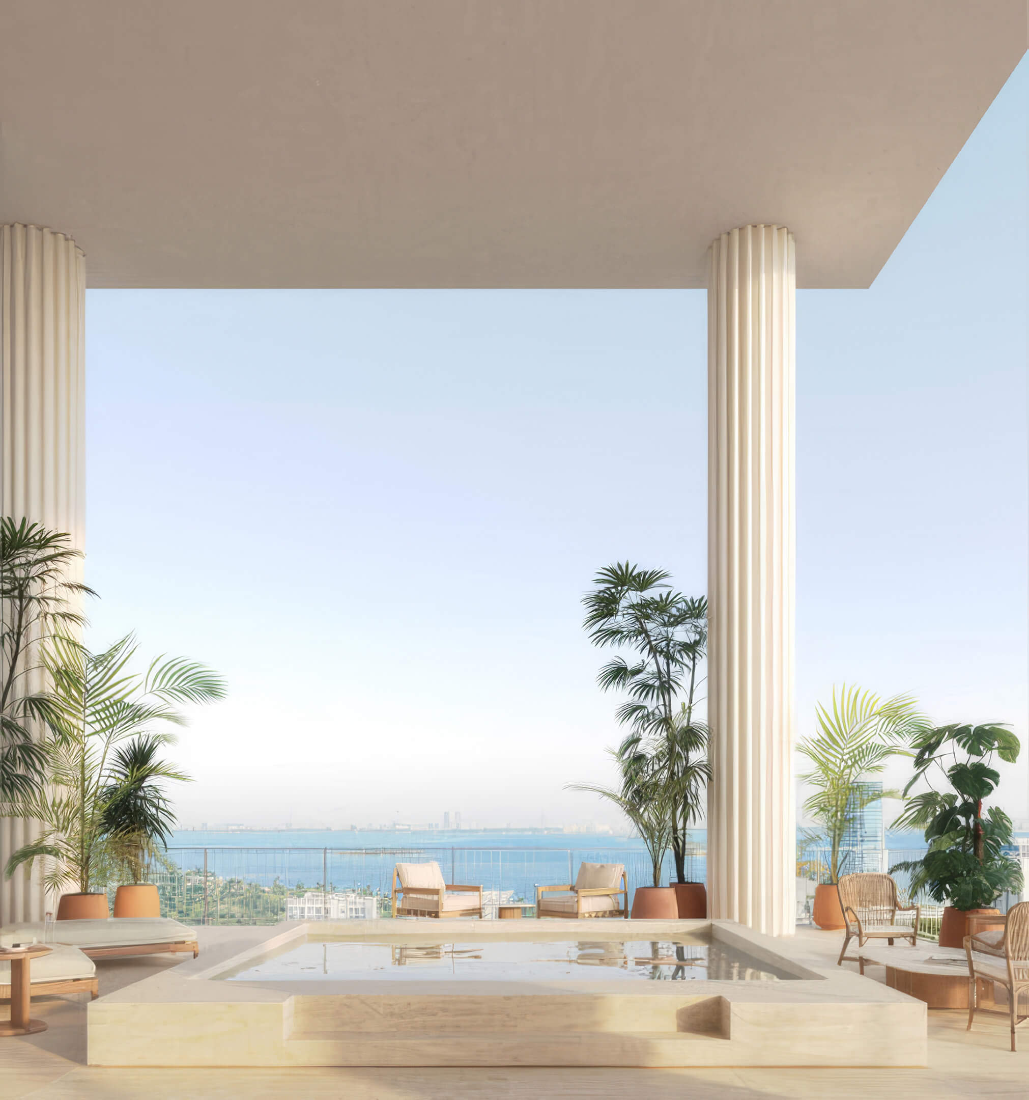 Covered spa plunge pool framed by tall columns, potted palms, and a bay view at Fouquet’s Hotel & Residences