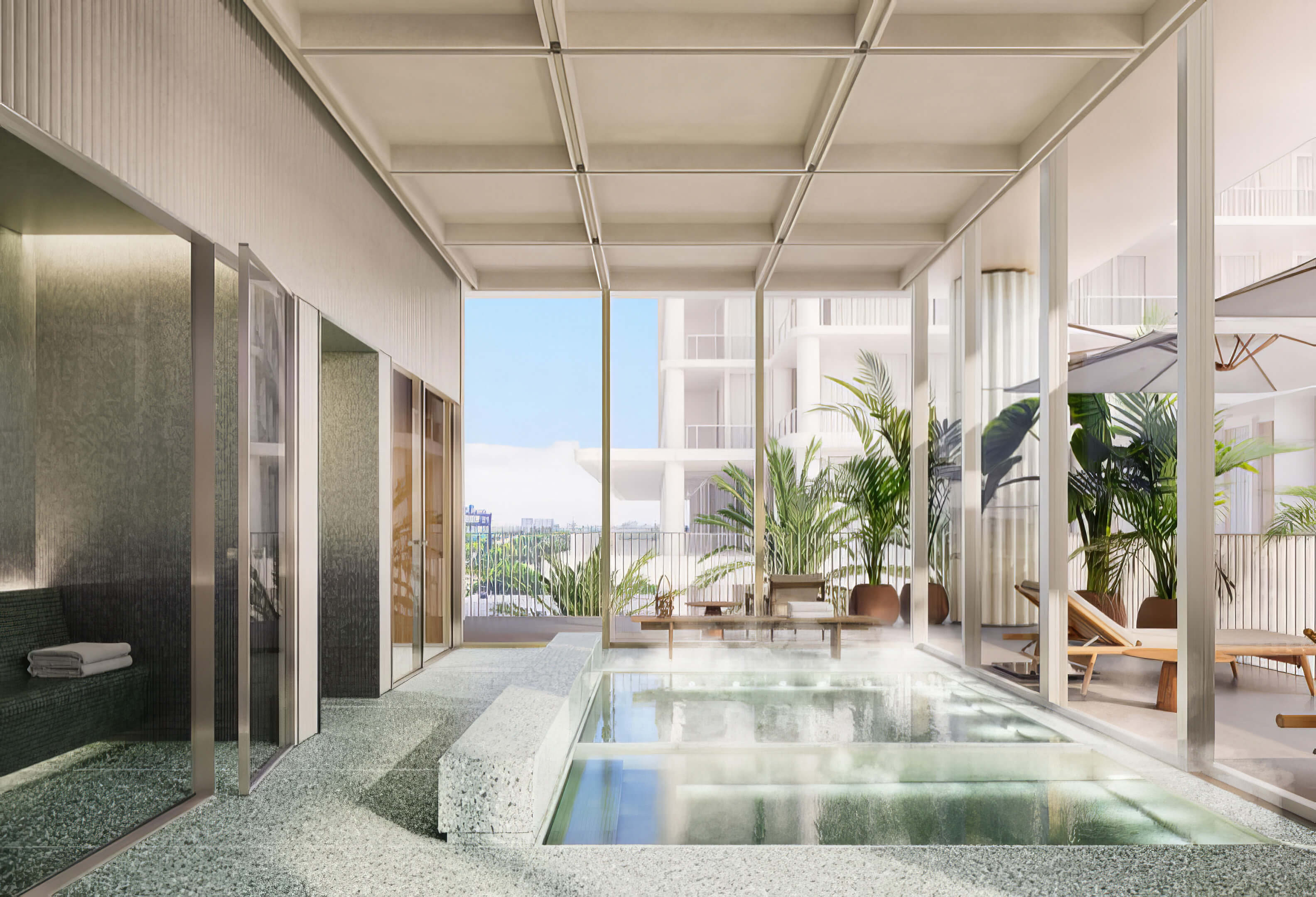 Indoor spa pool with submerged steps, dark tiled walls, and tall windows at Fouquet’s Hotel & Residences