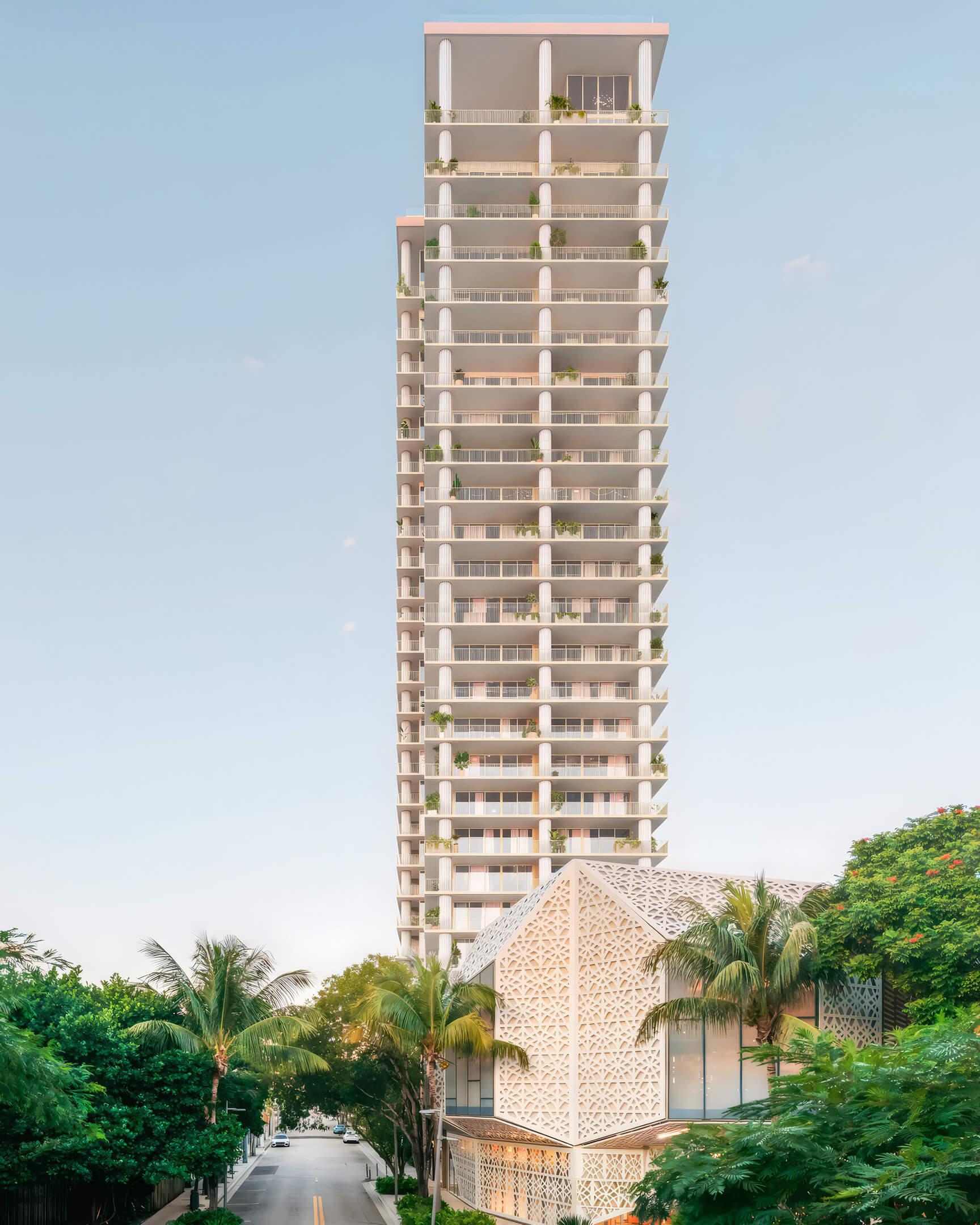 Slender residential tower rising above a patterned podium and palm trees at Fouquet’s Hotel & Residences