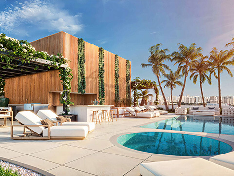 Sunset rooftop terrace at LEV Residences Aventura Miami with pool, spa, lounge chairs and palm trees