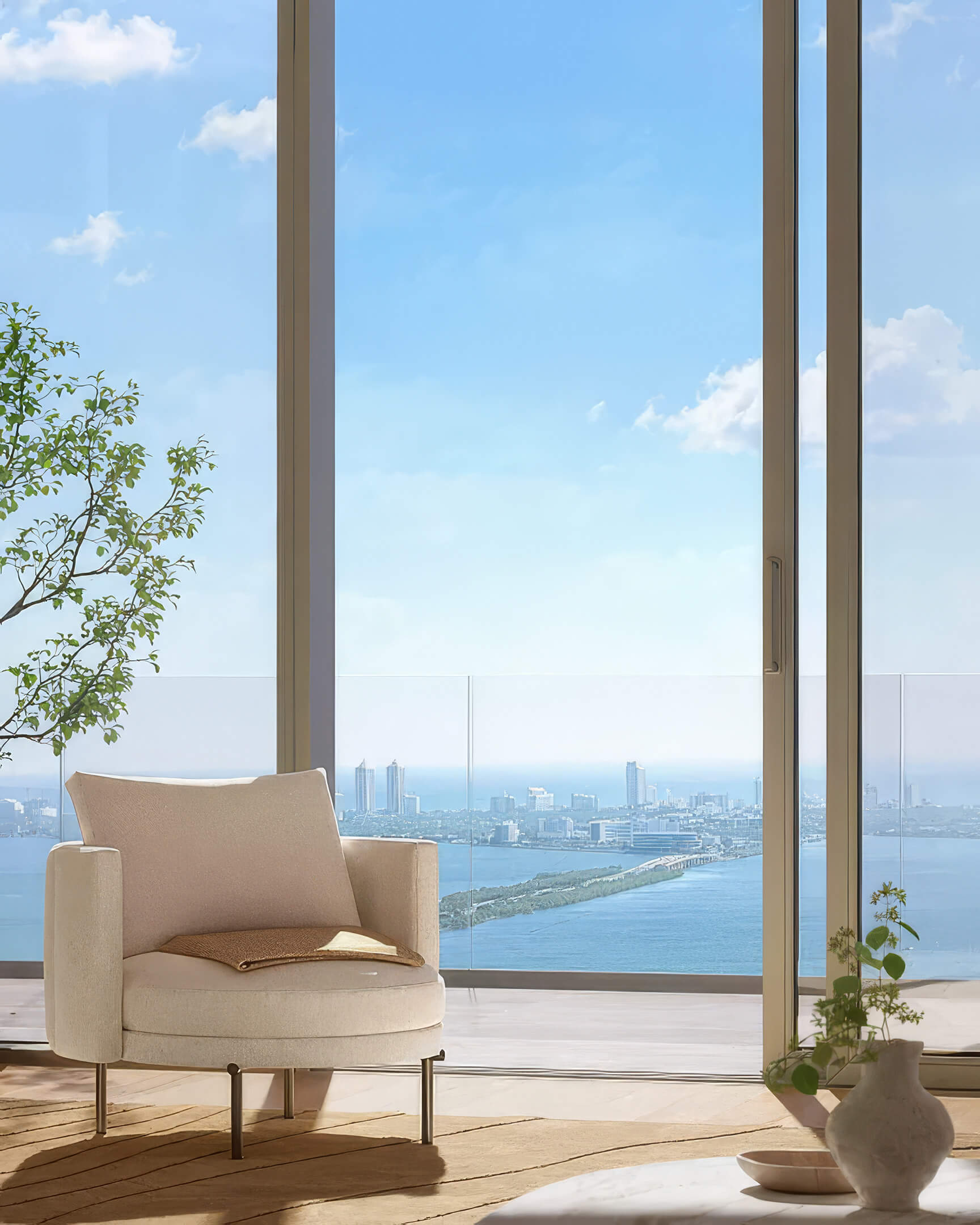 Armchair beside full height windows at Lilli Miami Edgewater overlooking the bay in daylight