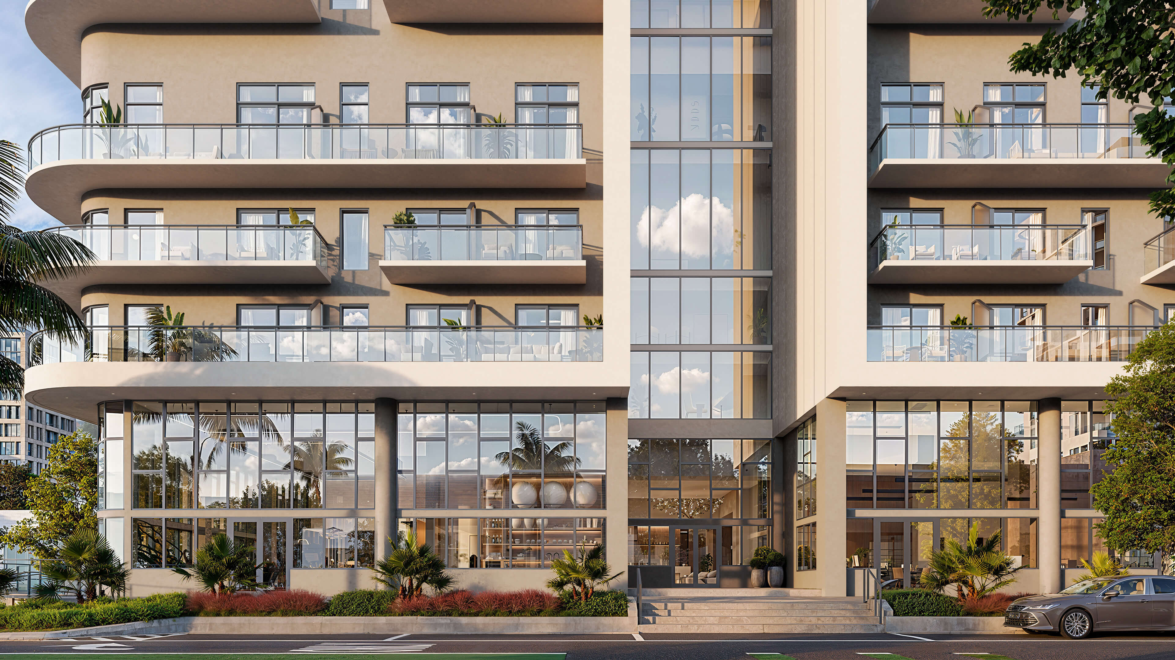 Glass balcony facade of NoBe Parc Miami Beach with modern entrance, landscaped frontage and contemporary design