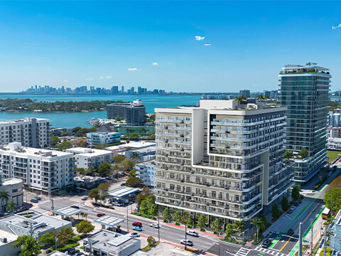 Neighborhood aerial view of NoBe Parc Miami Beach with Biscayne Bay, city skyline and nearby coastal buildings