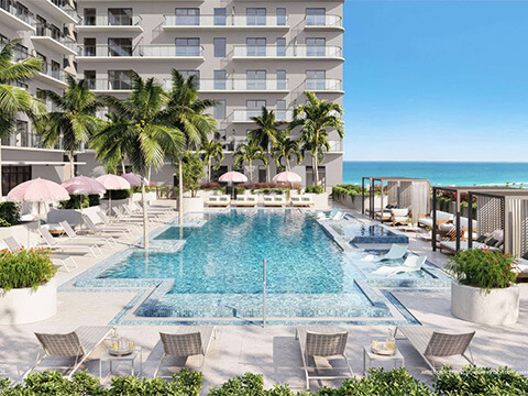 Resort style pool at NoBe Parc Miami Beach with ocean views, lounge chairs and tropical landscaping