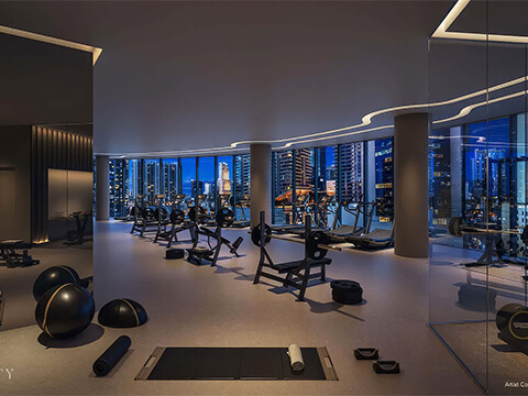 Fitness center at One Twenty Brickell Residences with cardio equipment, weights, and nighttime Brickell skyline views