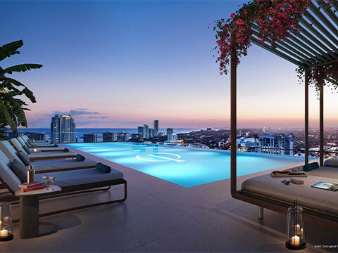 Rooftop pool at One Twenty Brickell Residences with sunset skyline views, lounge chairs, and luxury cabanas