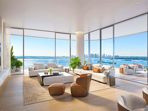 Panoramic living room at Pagani Residences in North Bay Village with expansive glass walls and waterfront skyline views
