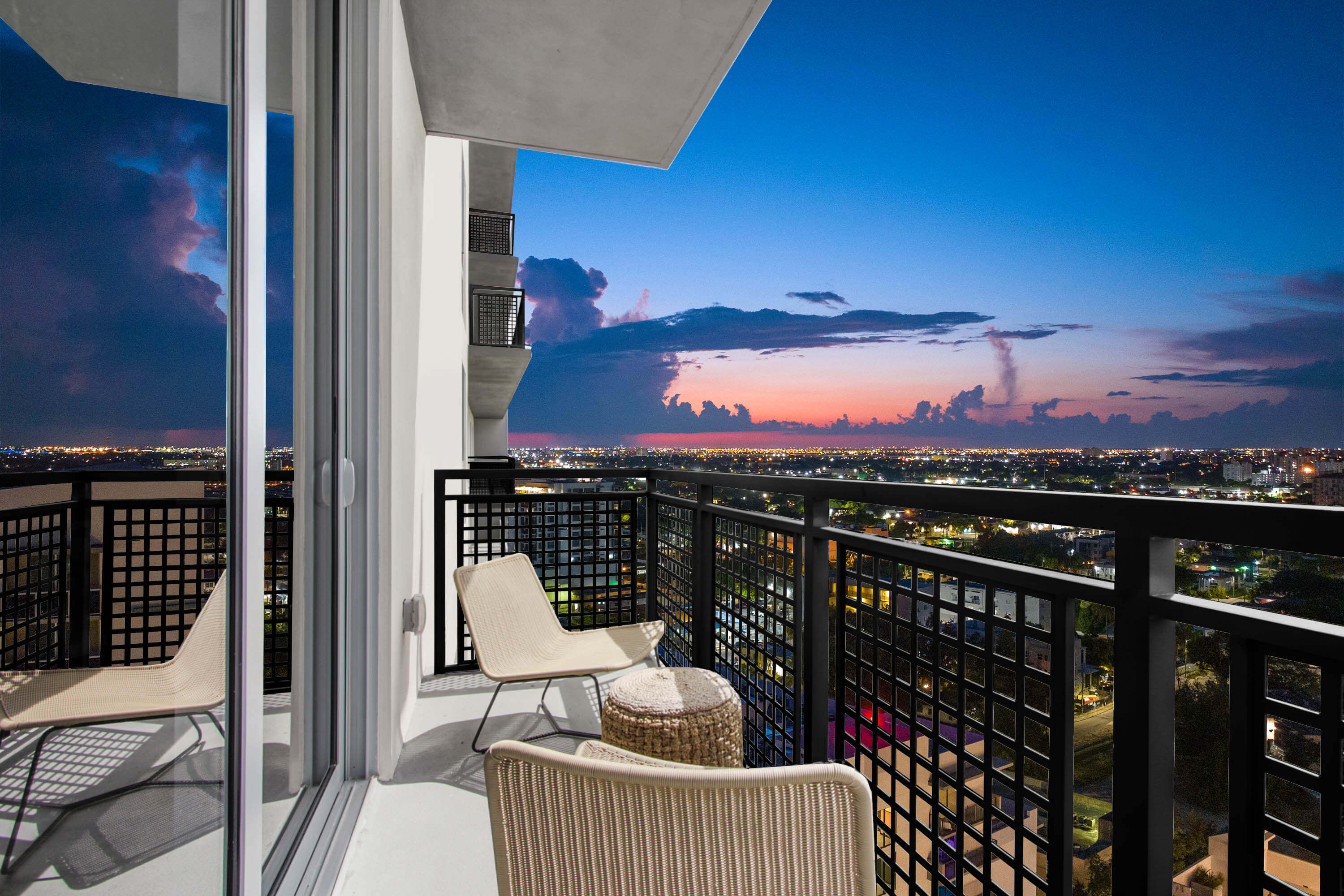 Night view from River District 14 balcony with lounge seating and skyline