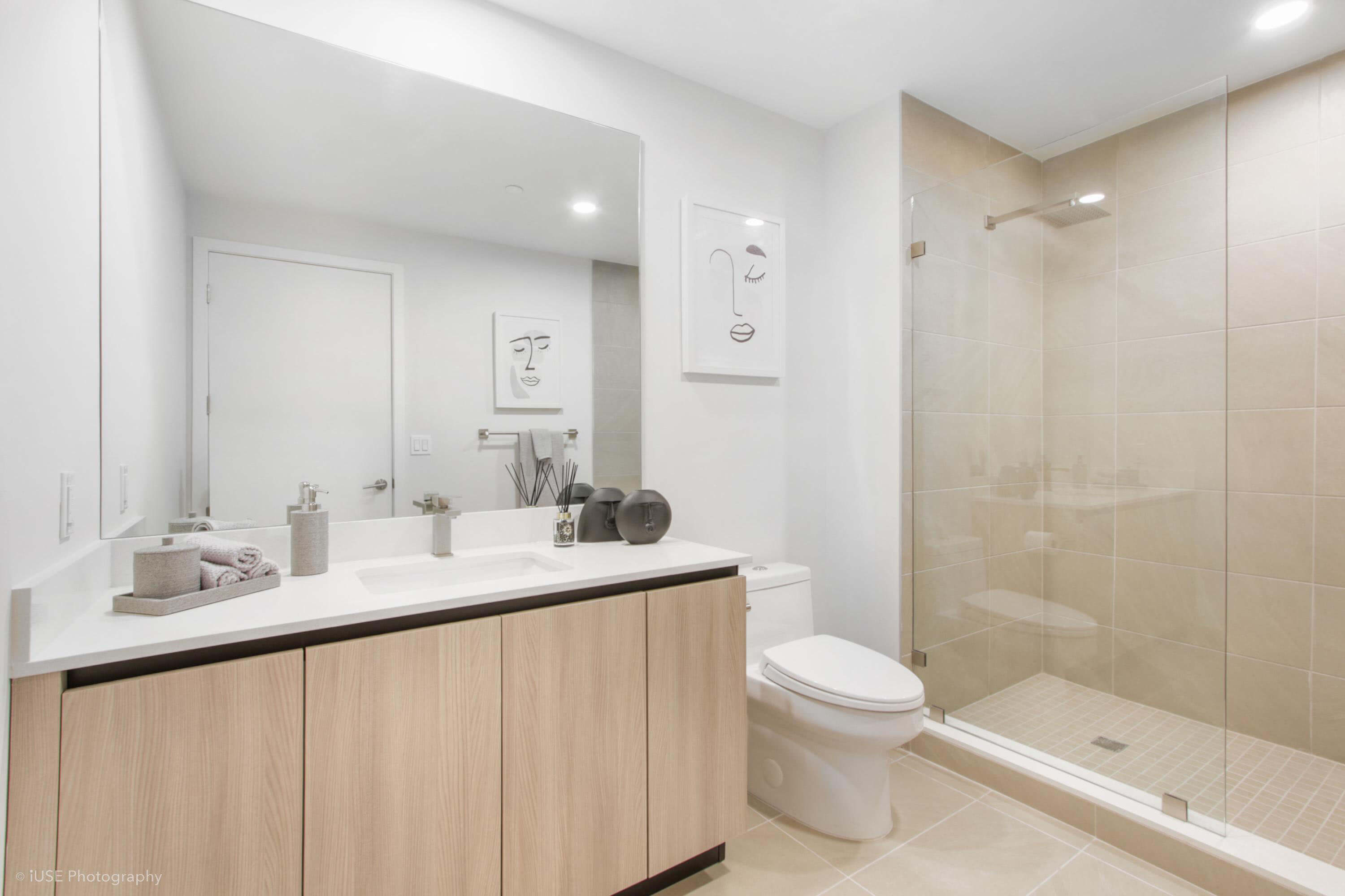 Modern bathroom with glass shower and minimalist design at River District 14
