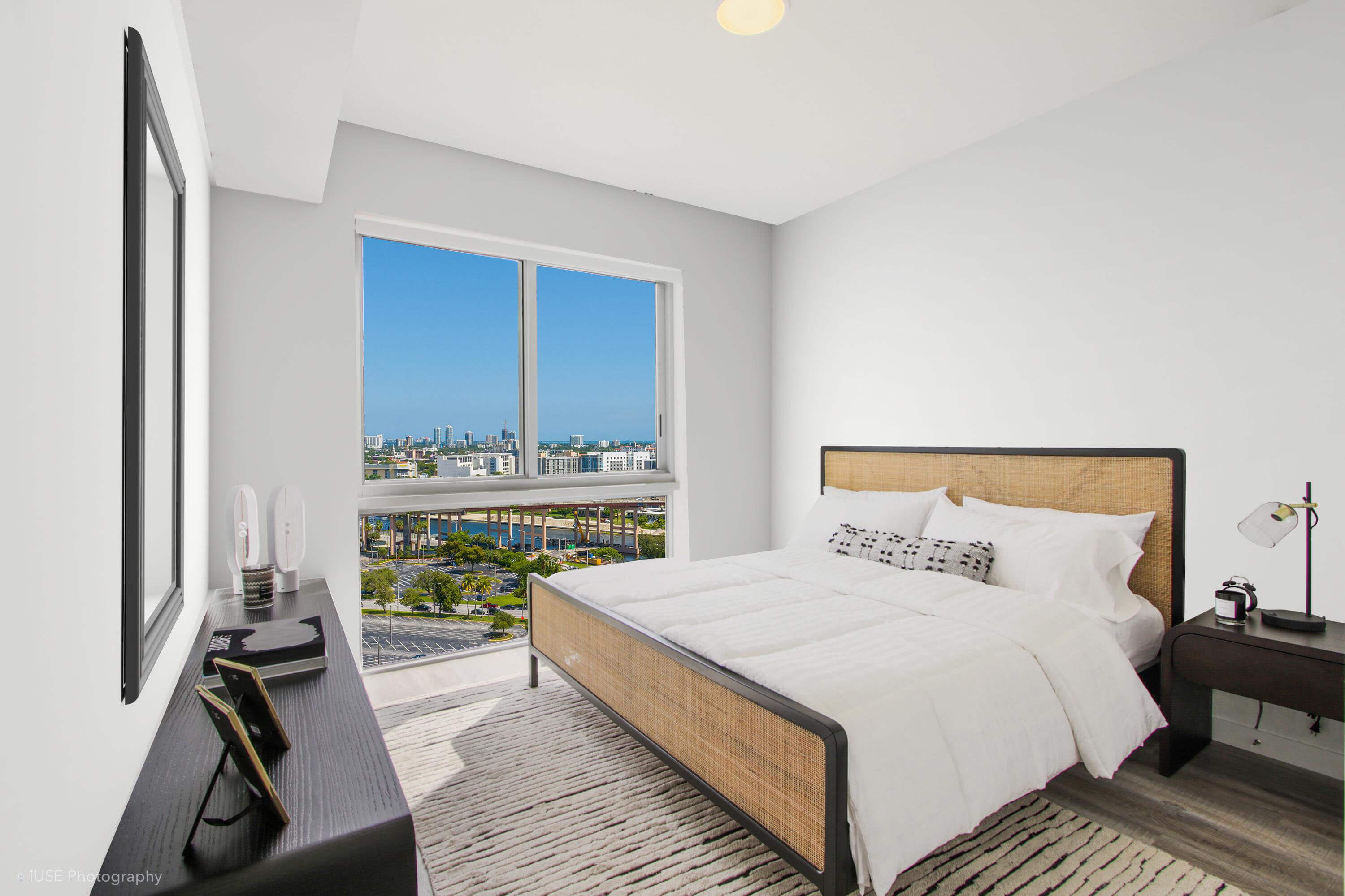 Cozy bedroom with large window and skyline view at River District 14
