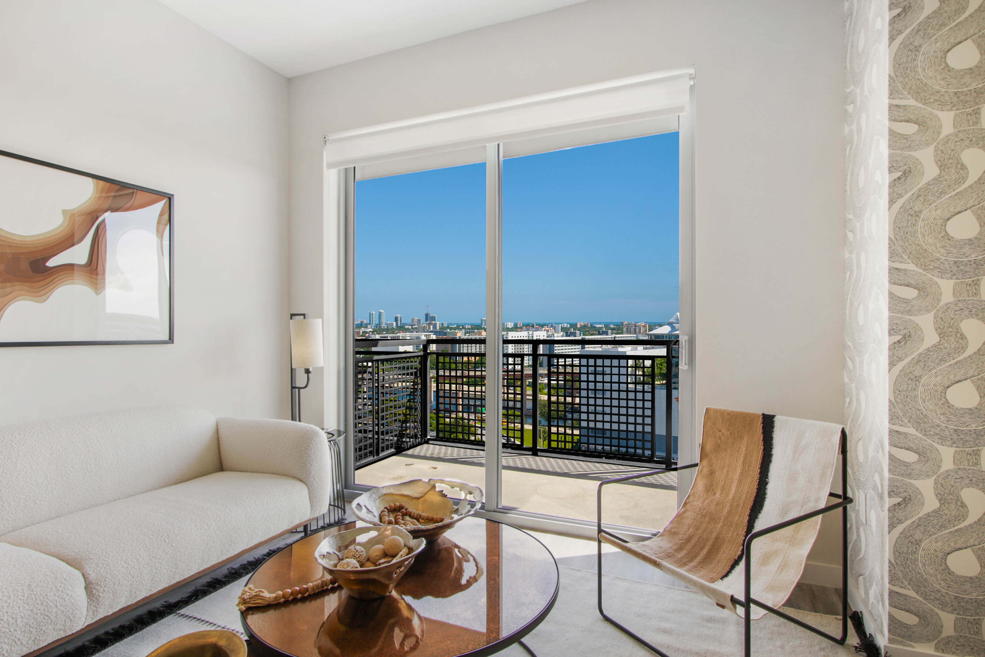 Living room with balcony access and skyline view from River District 14