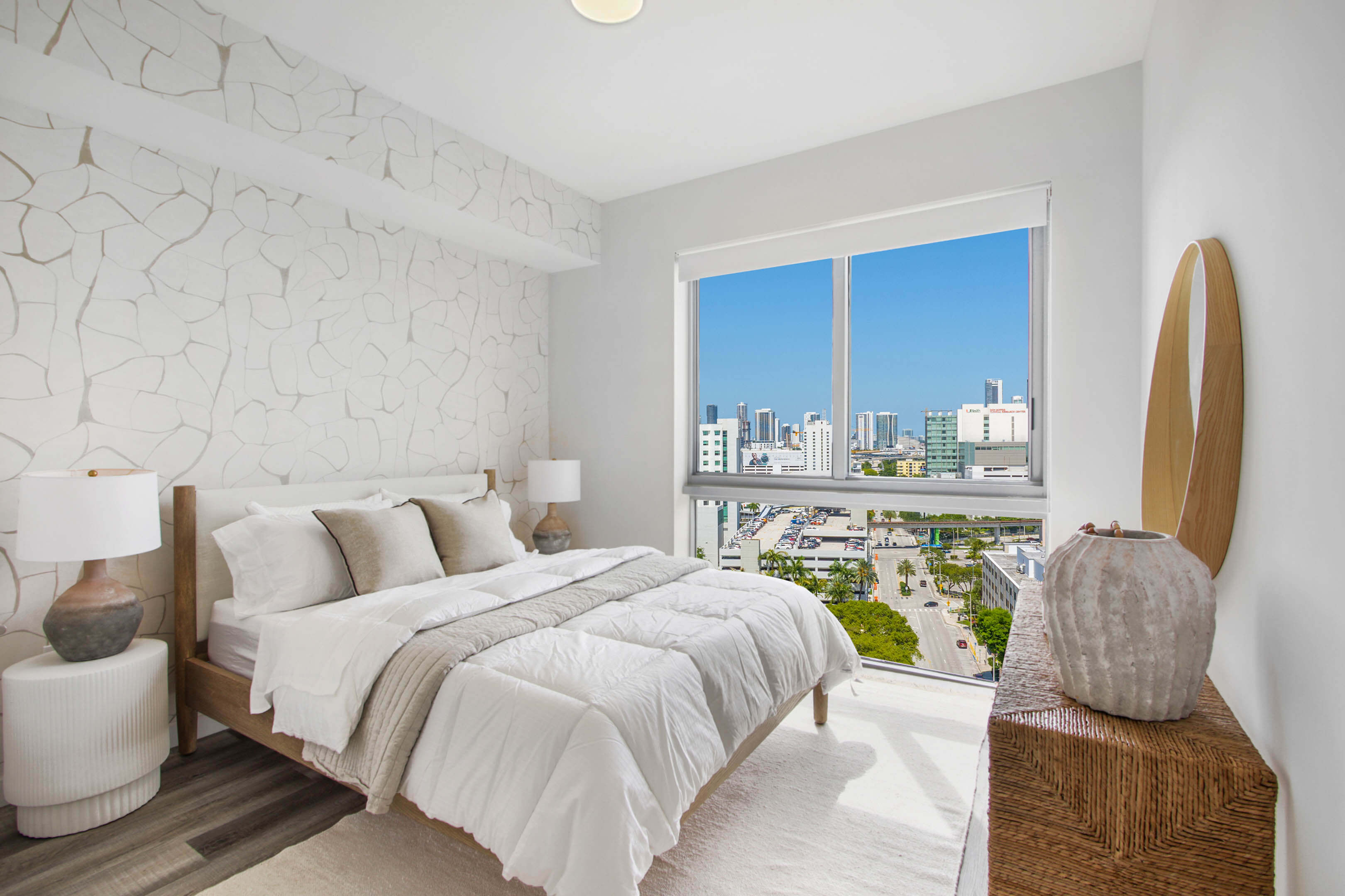 Modern bedroom with textured wall and sunny city view at River District 14