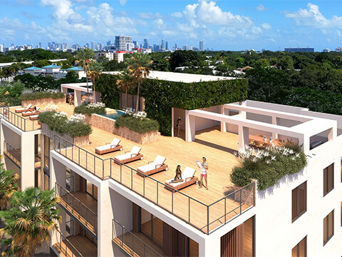 Rooftop terrace at Roble One Coconut Grove Miami with lounge areas, tropical landscaping and city skyline views