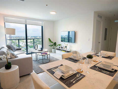 Open-concept model unit living and dining area at Smart Brickell Miami Tower II with balcony city views
