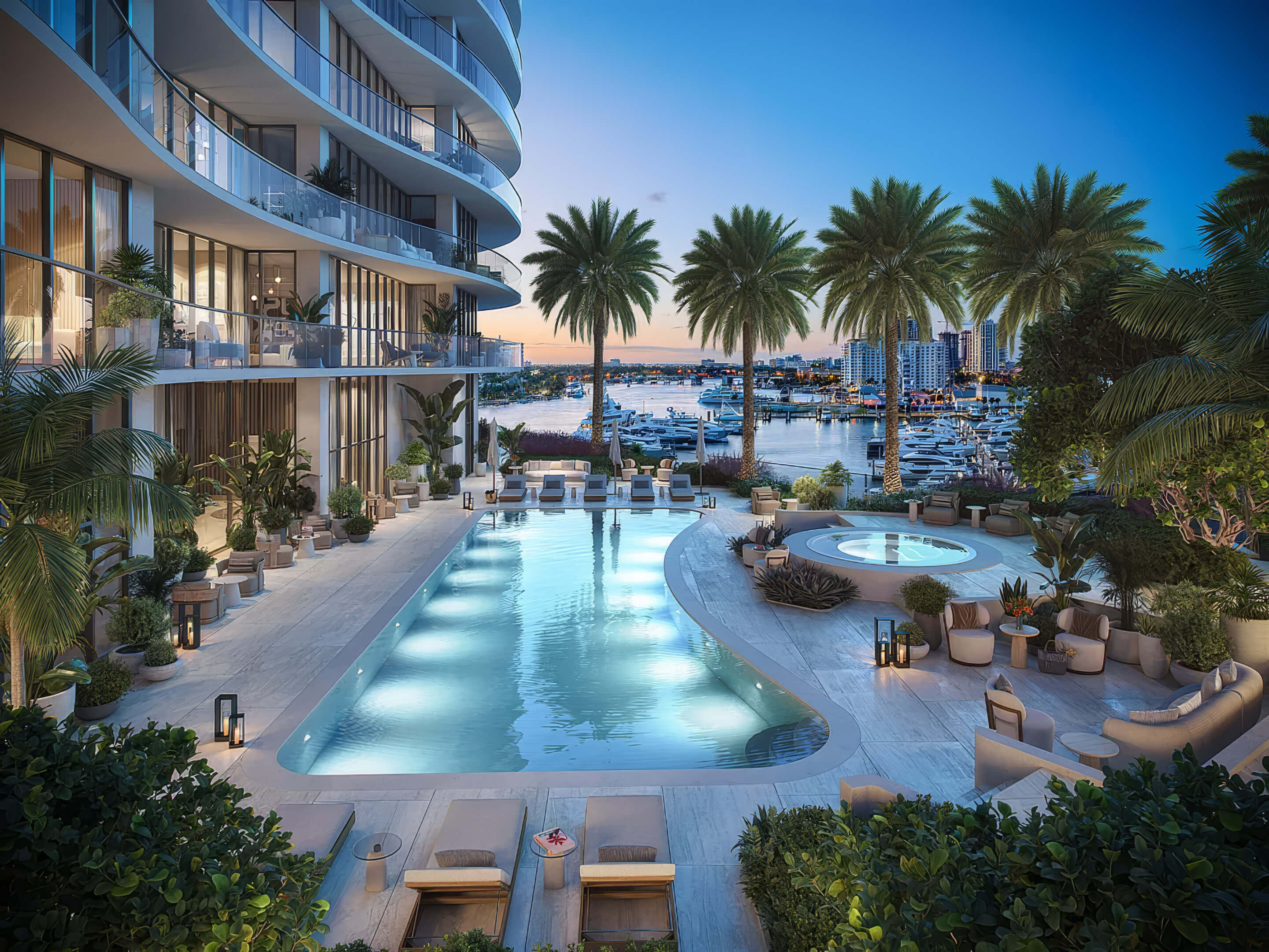 Illuminated outdoor pool and circular spa with marina views at dusk at St Regis Residences Bahia Mar