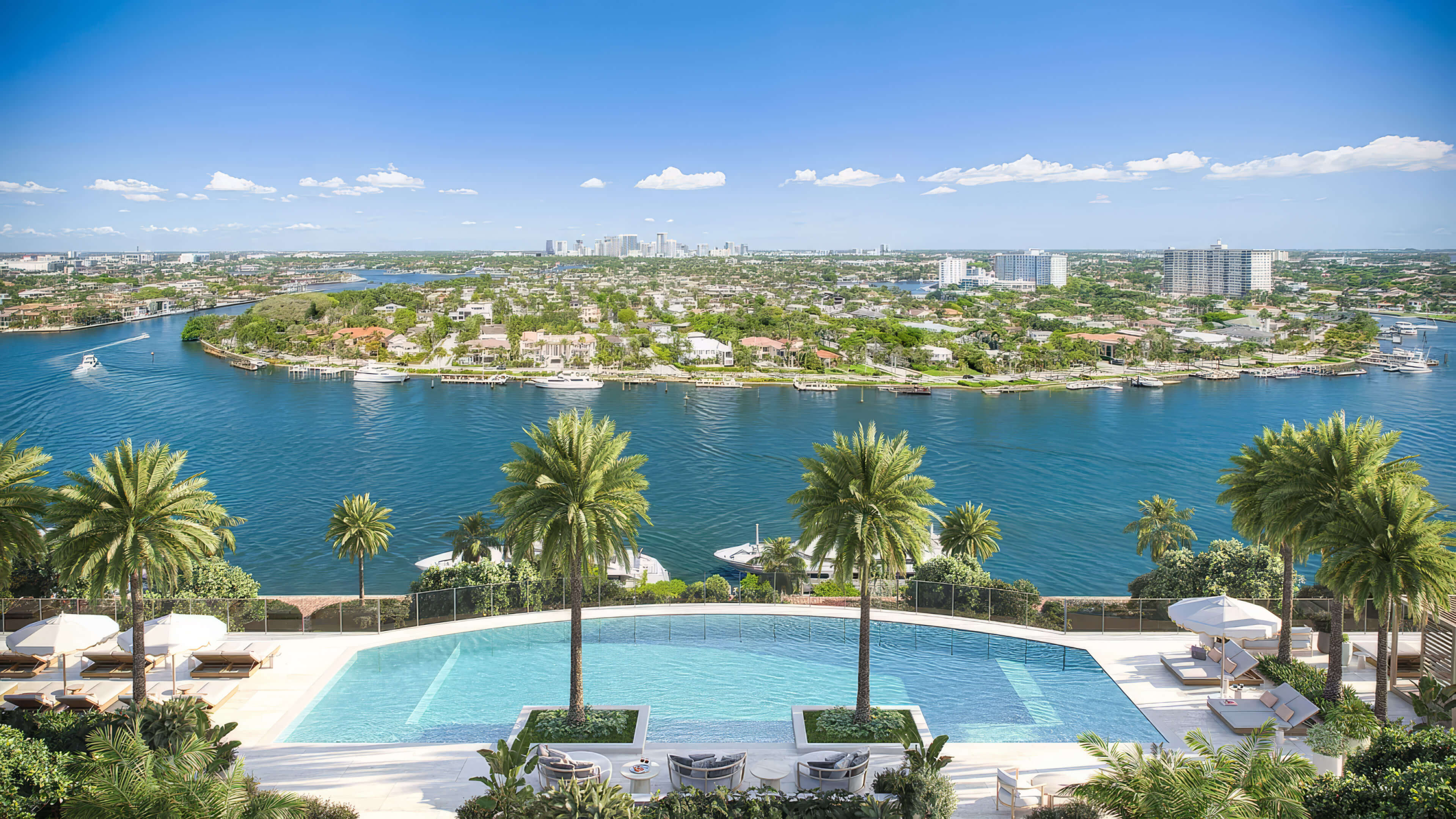 Elevated outdoor pool with palm trees and panoramic waterway views by day at St Regis Residences Bahia Mar