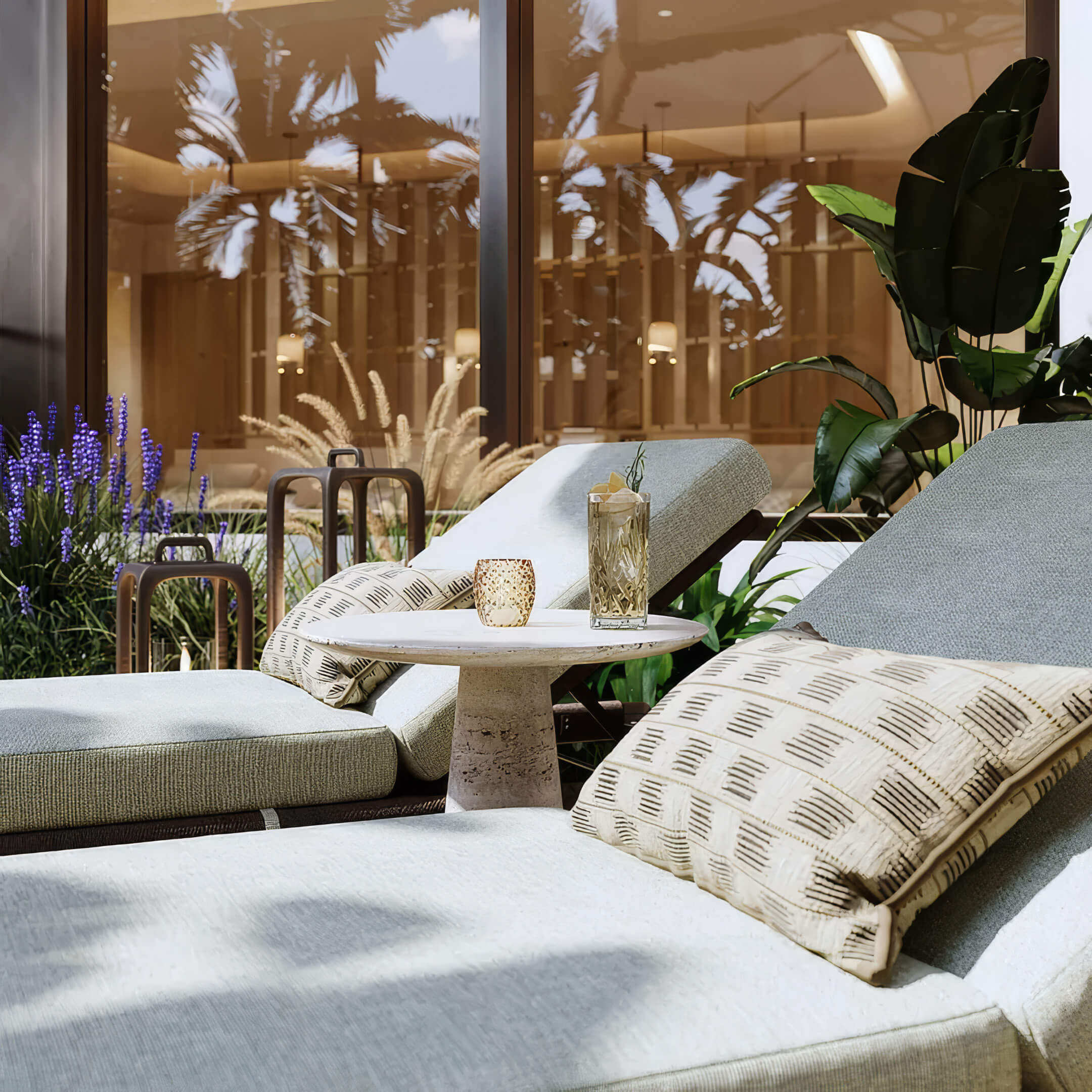 Spa loungers with patterned cushions beside garden-facing glass doors at St Regis Residences Bahia Mar