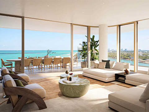 Corner residence living room at The Perigon Miami Beach with ocean views, bay views, curved glass windows, and private terrace