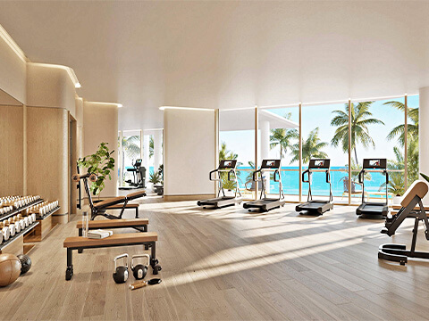 Fitness center at The Perigon Miami Beach with ocean views, treadmills, weights, and bright luxury wellness design