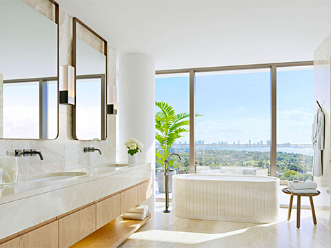Luxury bathroom at The Perigon Miami Beach with freestanding tub, dual vanity, marble finishes, and bay views