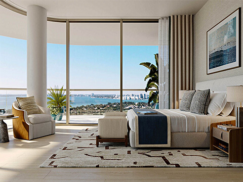 Primary bedroom at The Perigon Miami Beach with floor-to-ceiling windows, elegant interiors, and bay water views