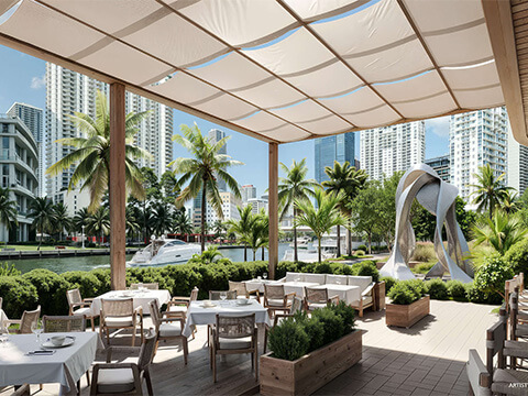 Avra dining terrace at The Standard Residences Brickell with white tablecloths, palm trees, and a curved canopy