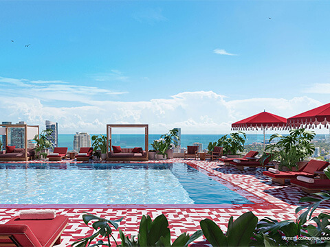 The Standard Residences Brickell rooftop pool with red loungers, striped umbrellas, and skyline views