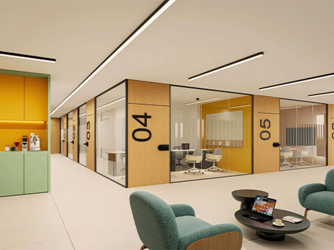 Coworking area at WOMA Wynwood with private glass offices, lounge seating and modern workspace design